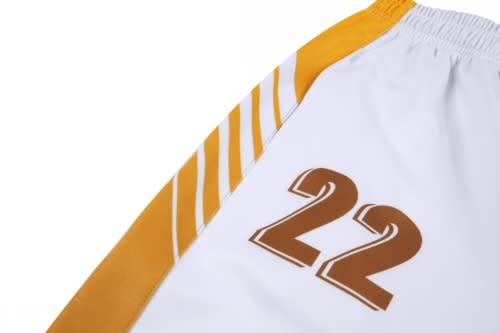A white cricket uniform with orange accents and the number 22 printed on the side. Includes a logo.