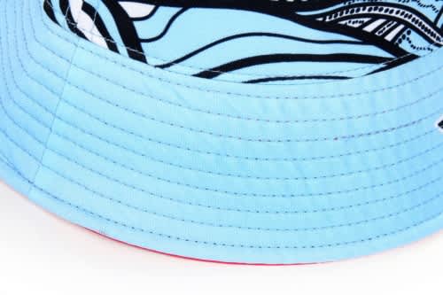 A reversible bucket hat featuring a light blue exterior with a patterned inner side, including a logo.