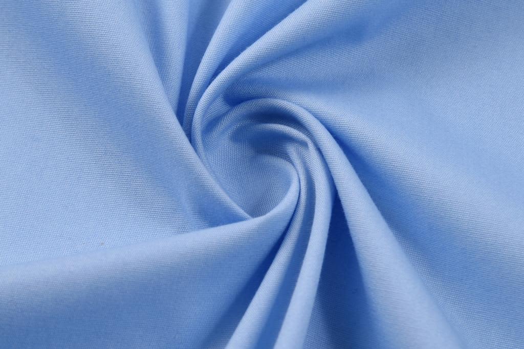 A light blue fabric in a spiral pattern, showcasing a smooth texture suitable for clothing.