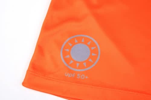 An orange quarter-zip suit featuring a sun logo, designed as a uniform for lifeguards.