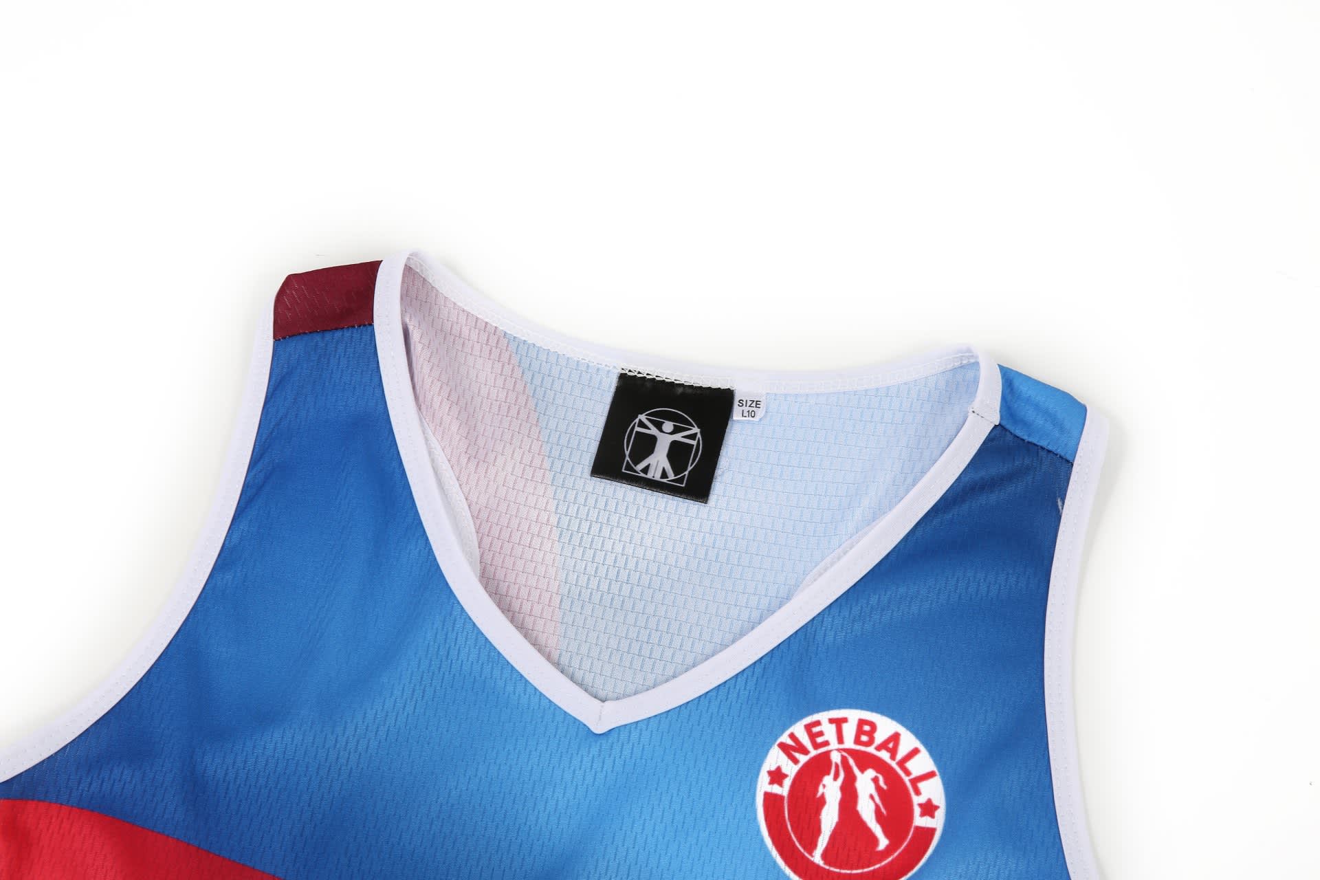 A netball dress in blue with red accents, featuring a logo on the front and a mesh neckline.