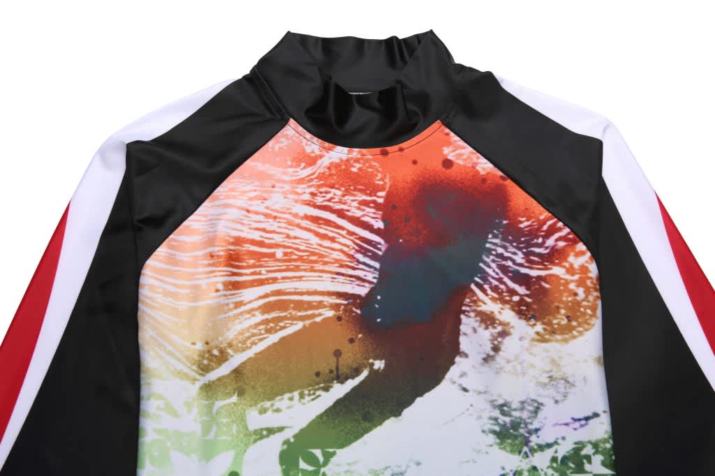 A colourful sublimation rashie club tee featuring an abstract design in orange, red, and black with a high neckline.