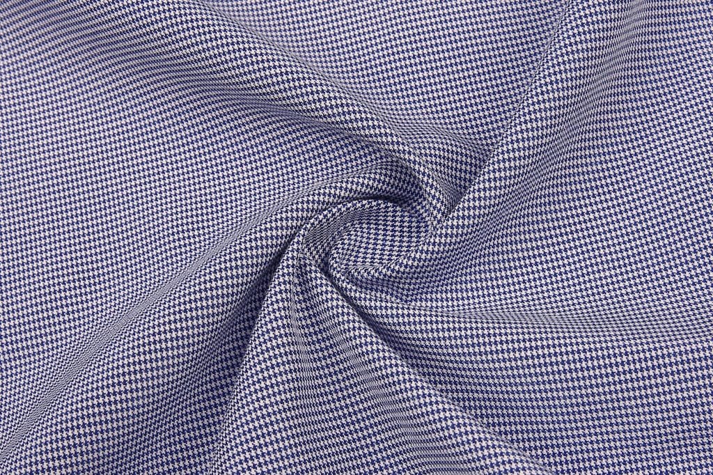 A close-up of fabric featuring a blue and white checkered pattern, showcasing its texture and weave.