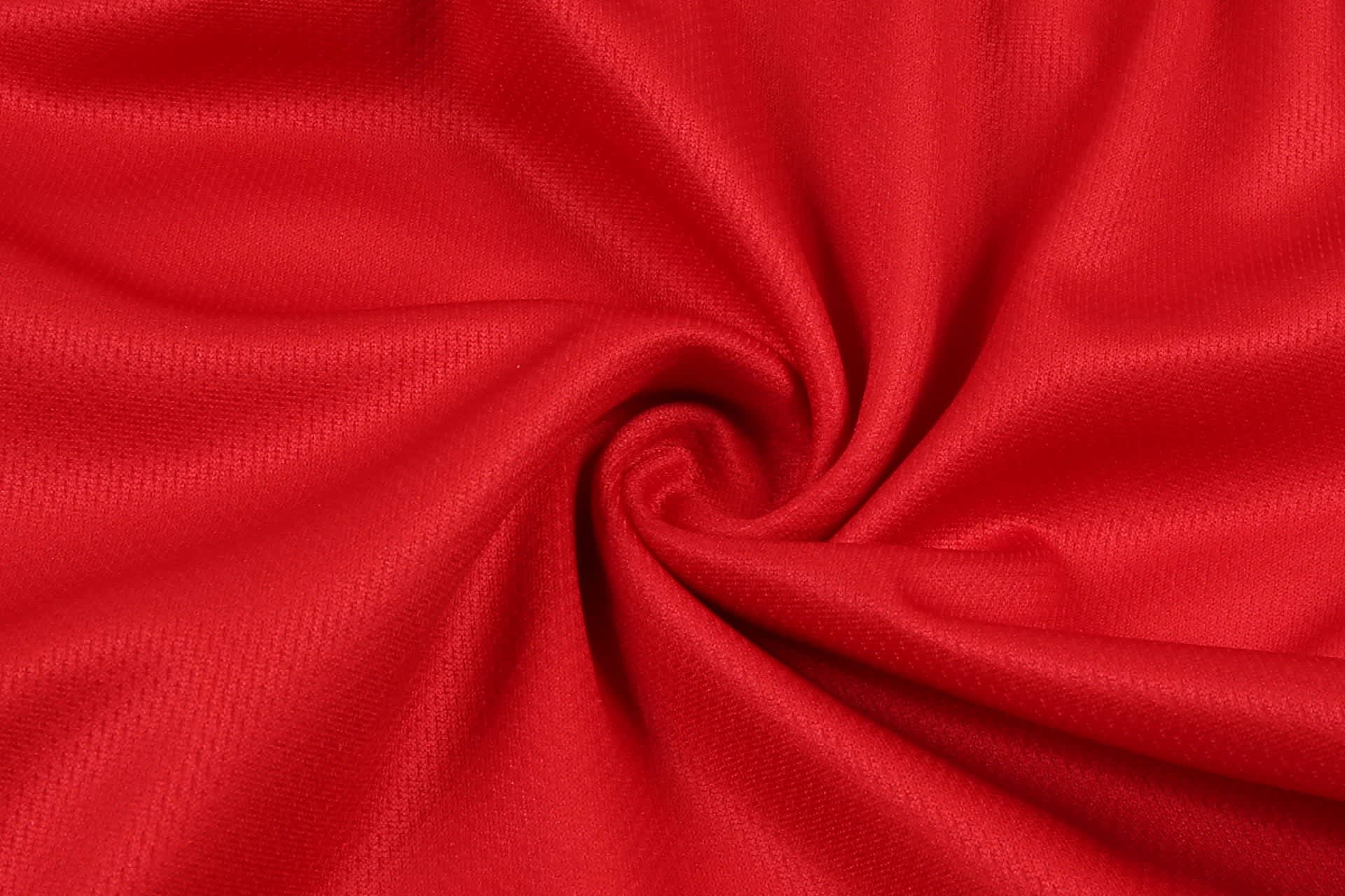 A red fabric with a smooth texture, arranged in a spiral pattern. Suitable for women's volleyball uniform shorts.