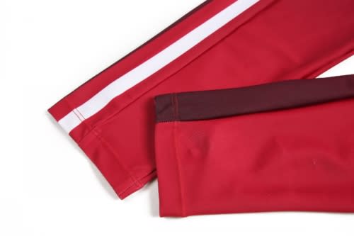 Red sports uniform shorts with white stripes and contrasting dark red detailing. Features logo branding.