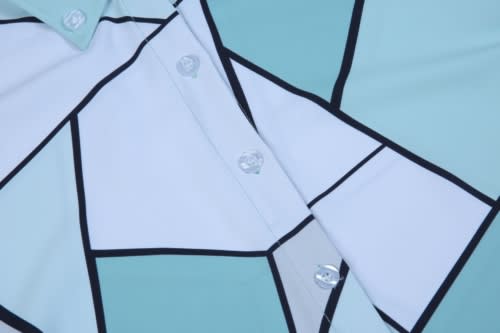 Custom shirt featuring a geometric pattern in shades of teal, white, and black, with buttons in the centre.