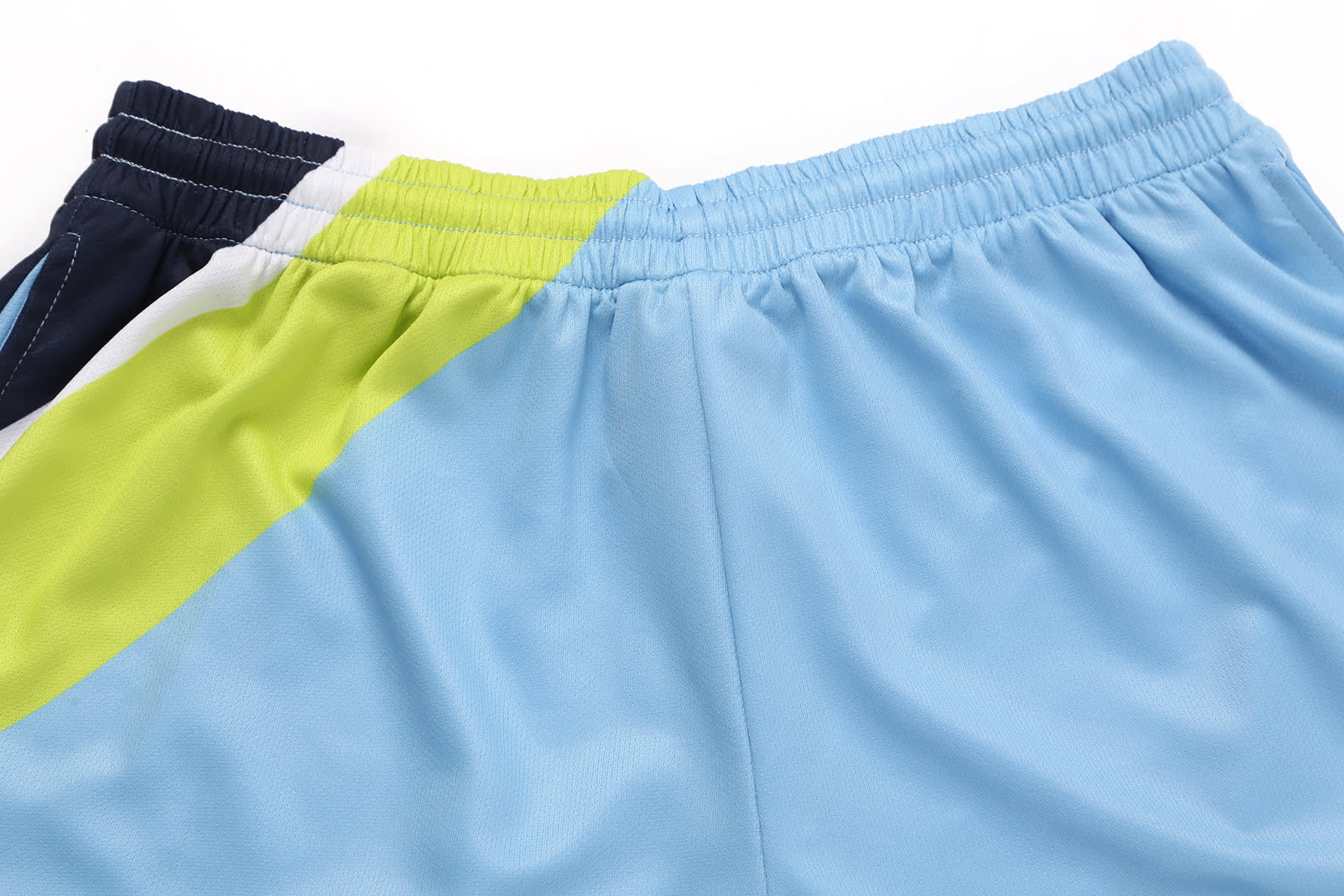Athletic shorts featuring a split design with light blue, dark blue, and vibrant green colours. Includes branding.
