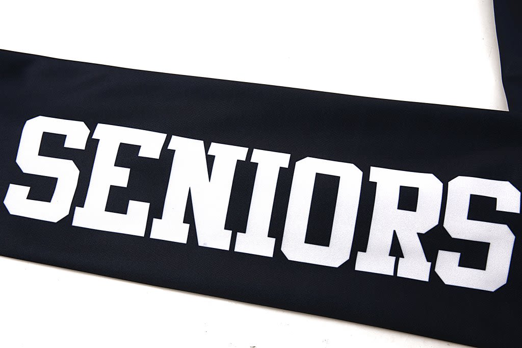 A black leavers jacket featuring white lettering that reads "SENIORS". The item has a logo.