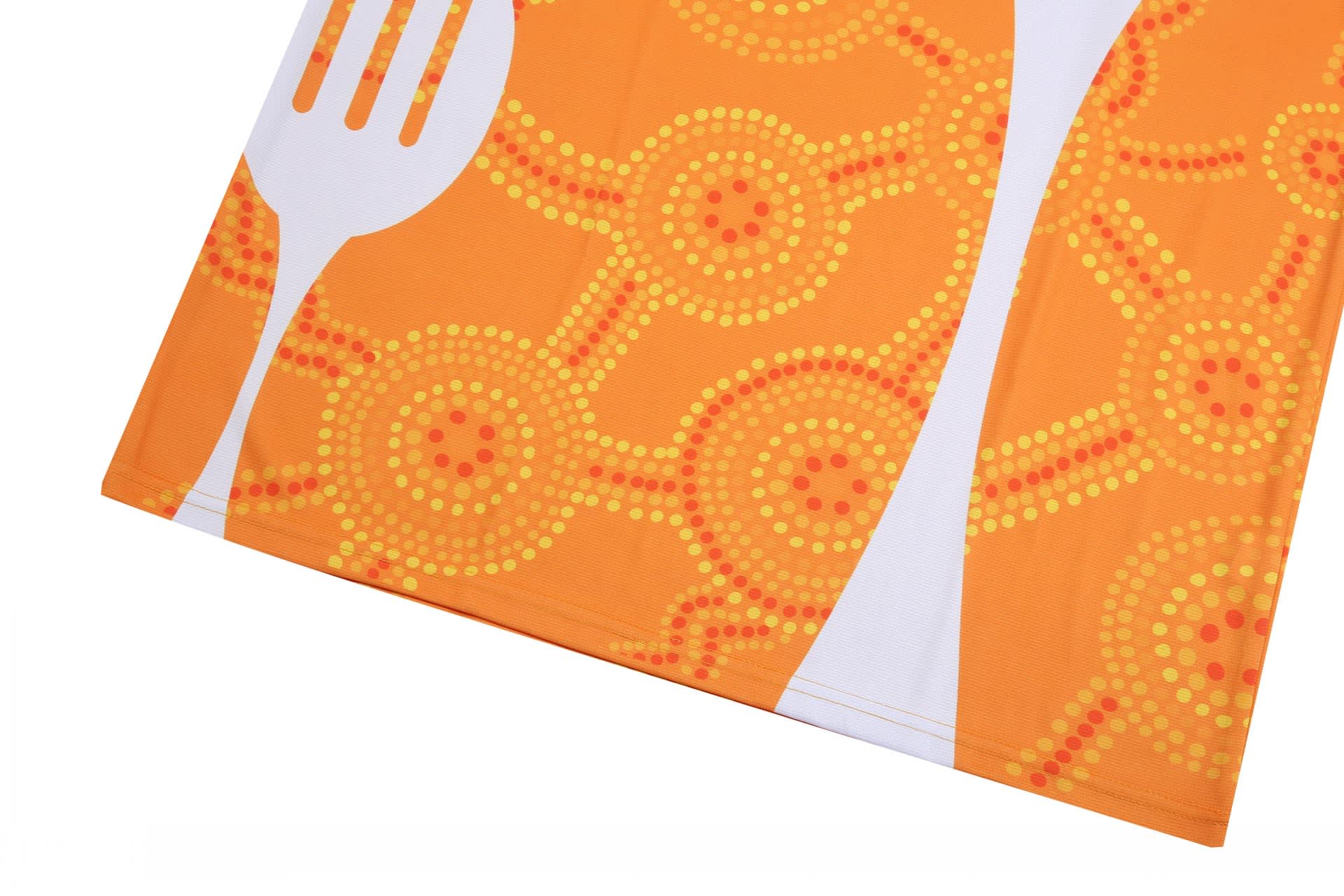 An orange dining room uniform featuring a fork design and circular patterns in shades of yellow and red.