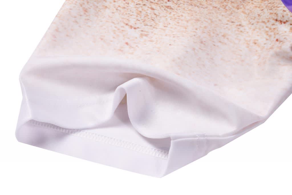 A short tee featuring a sandy beach design, predominantly in shades of white and beige, with a branding logo.