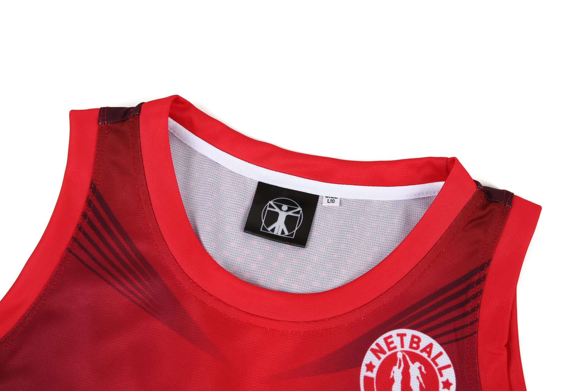 A red netball dress featuring a mesh neckline and a logo. The design includes a sporty aesthetic with contrasting details.