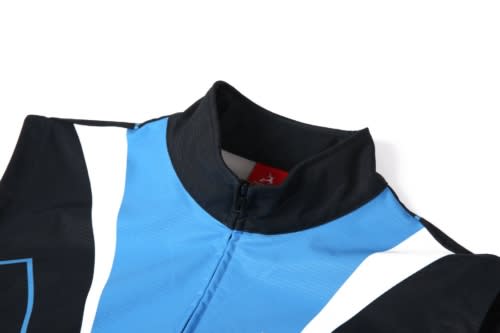 A black and blue soft shell waistcoat featuring a high collar and a zip. It has a logo on the fabric.