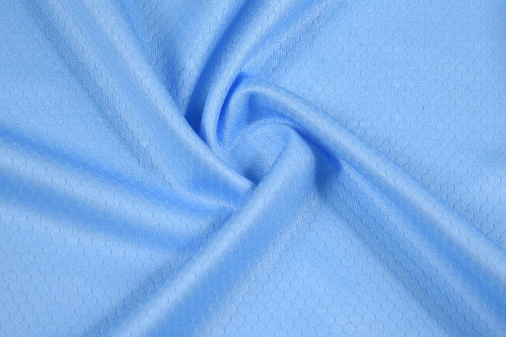 A light blue fabric with a subtle honeycomb pattern, showcasing a smooth, soft texture.