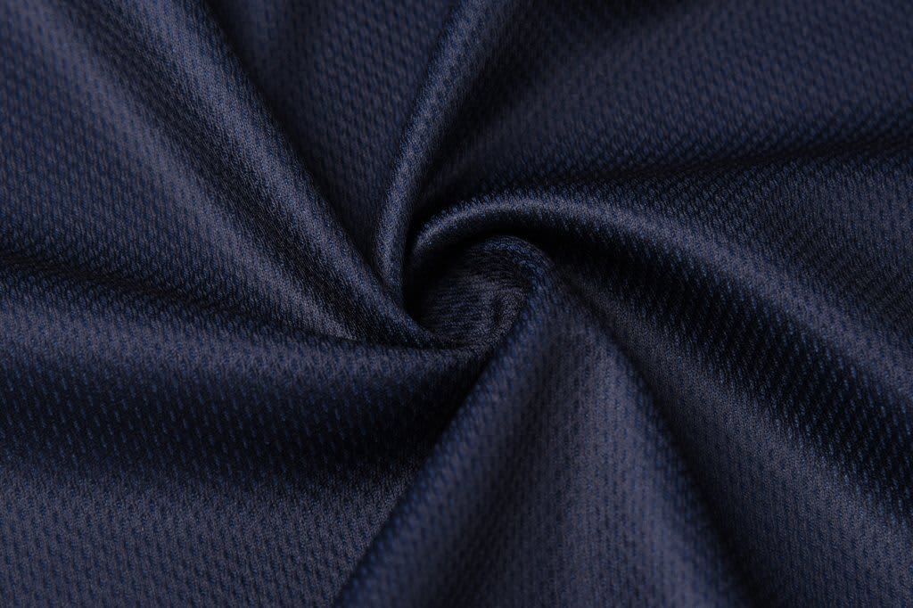 A navy blue fabric with a textured, breathable pattern, arranged in a spiraled fold.