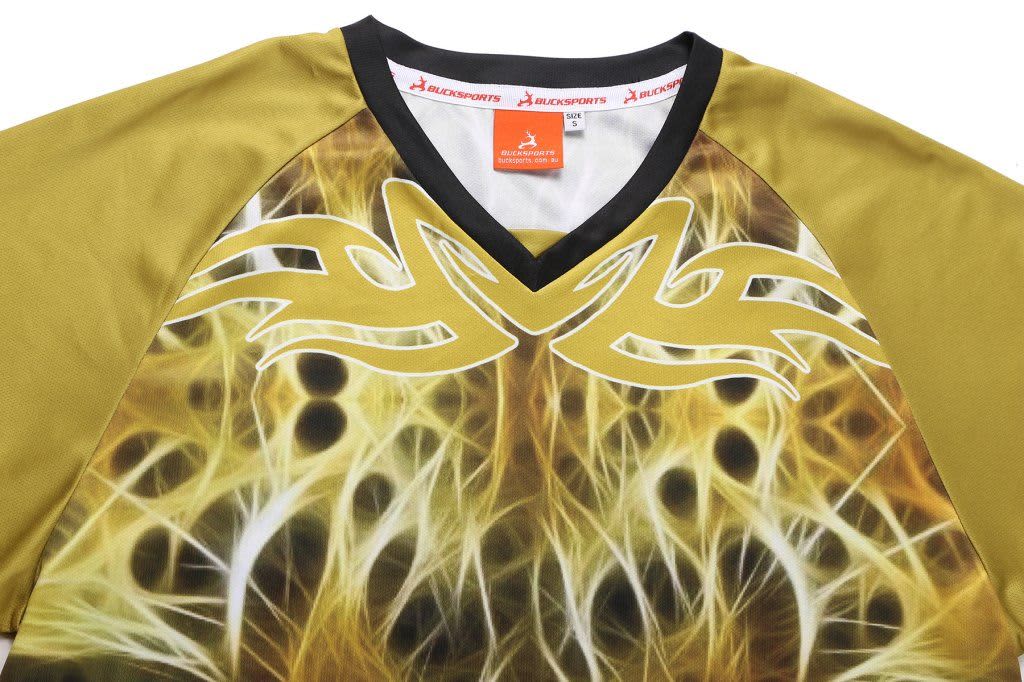 A sublimated T-shirt featuring vibrant yellow and brown designs, with a black V-neck collar and a logo on the label.