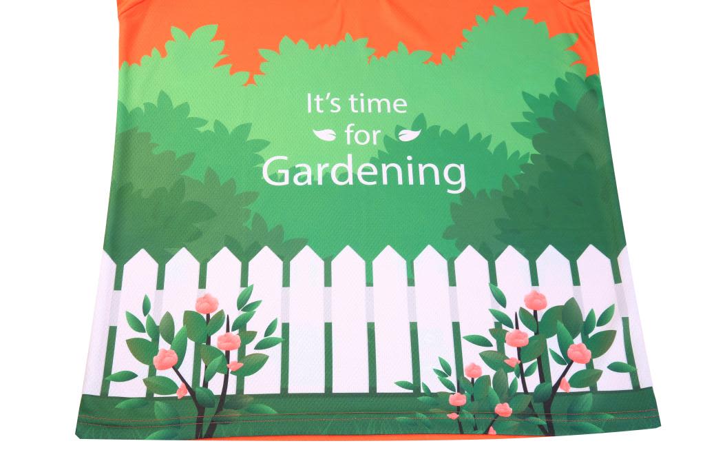 A vibrant green and orange shirt featuring a garden scene with flowers and a white picket fence.