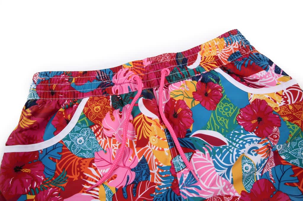 Vibrant multicoloured women's boardshorts featuring a floral pattern and an elastic waistband with drawstrings.