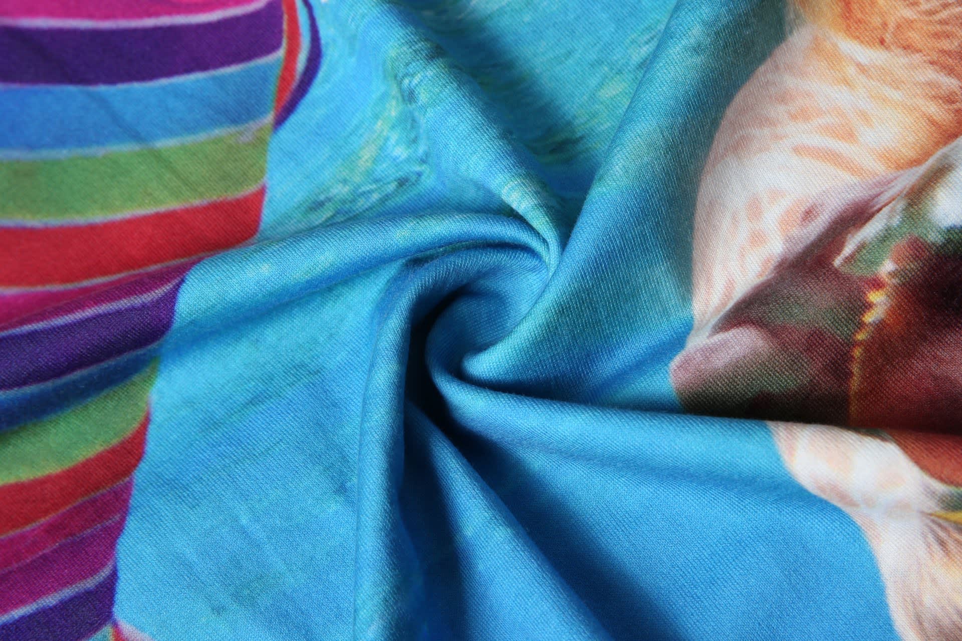 A blue cotton tee featuring vibrant colours and patterns, with a smooth fabric texture.