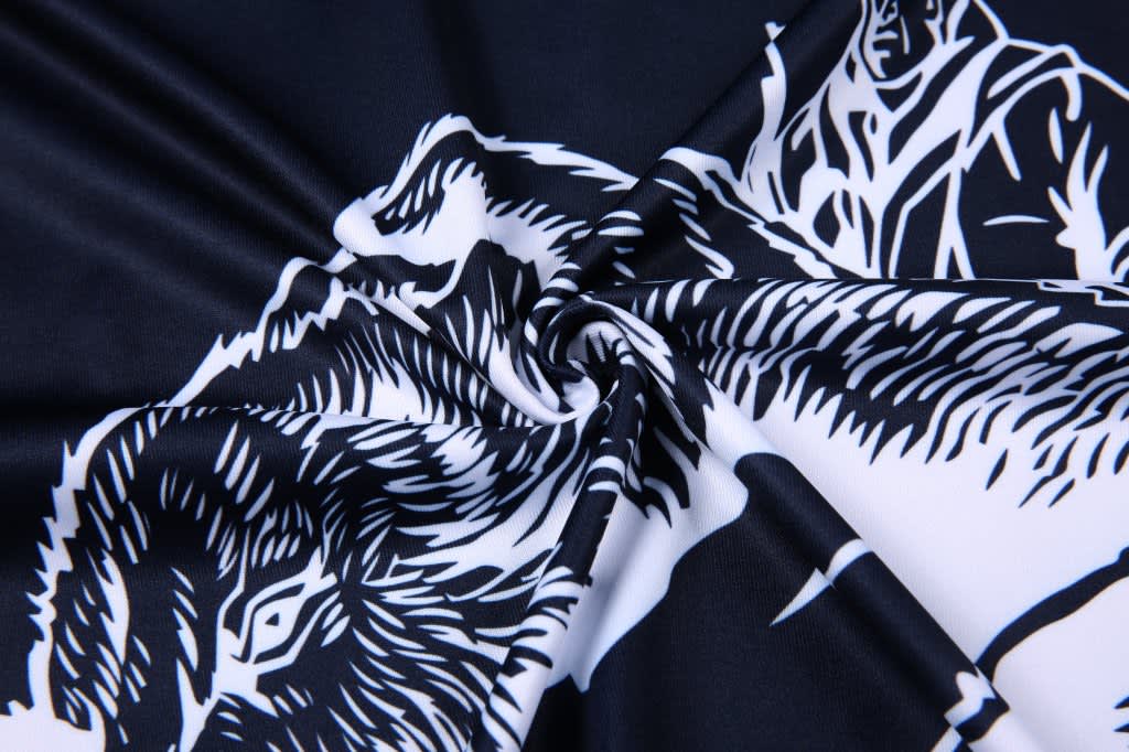 A fabric featuring a swirling design in black and white, showcasing detailed animal motifs.