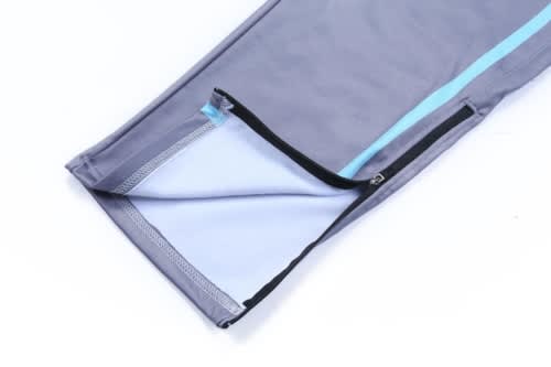 Training zip pants in grey with a light blue stripe, featuring a zippered opening at the hem.