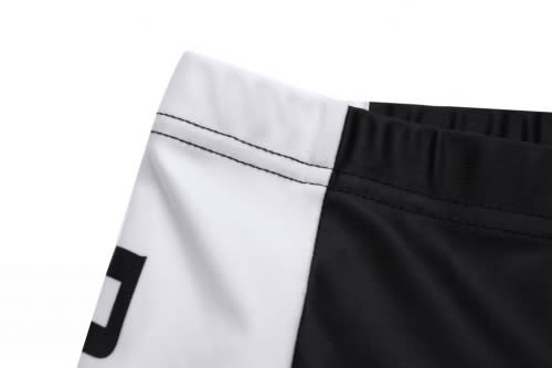 A close-up of bicycle team wear featuring a black and white design with visible stitching and a logo.