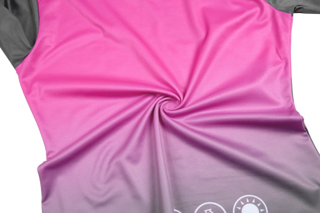 A pink and grey sports team T-shirt, featuring a smooth, swirling fabric design. It includes a logo on the bottom.