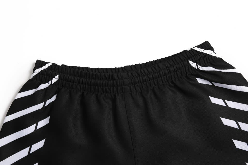 Black football shorts with a striped design and an elastic waistband, featuring a branding logo.