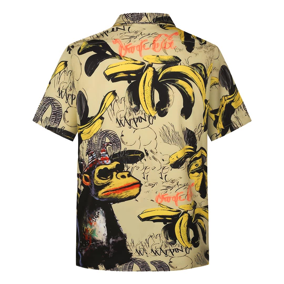 A short-sleeve shirt featuring a yellow pattern with bananas and a monkey graphic, adorned with various artistic elements.
