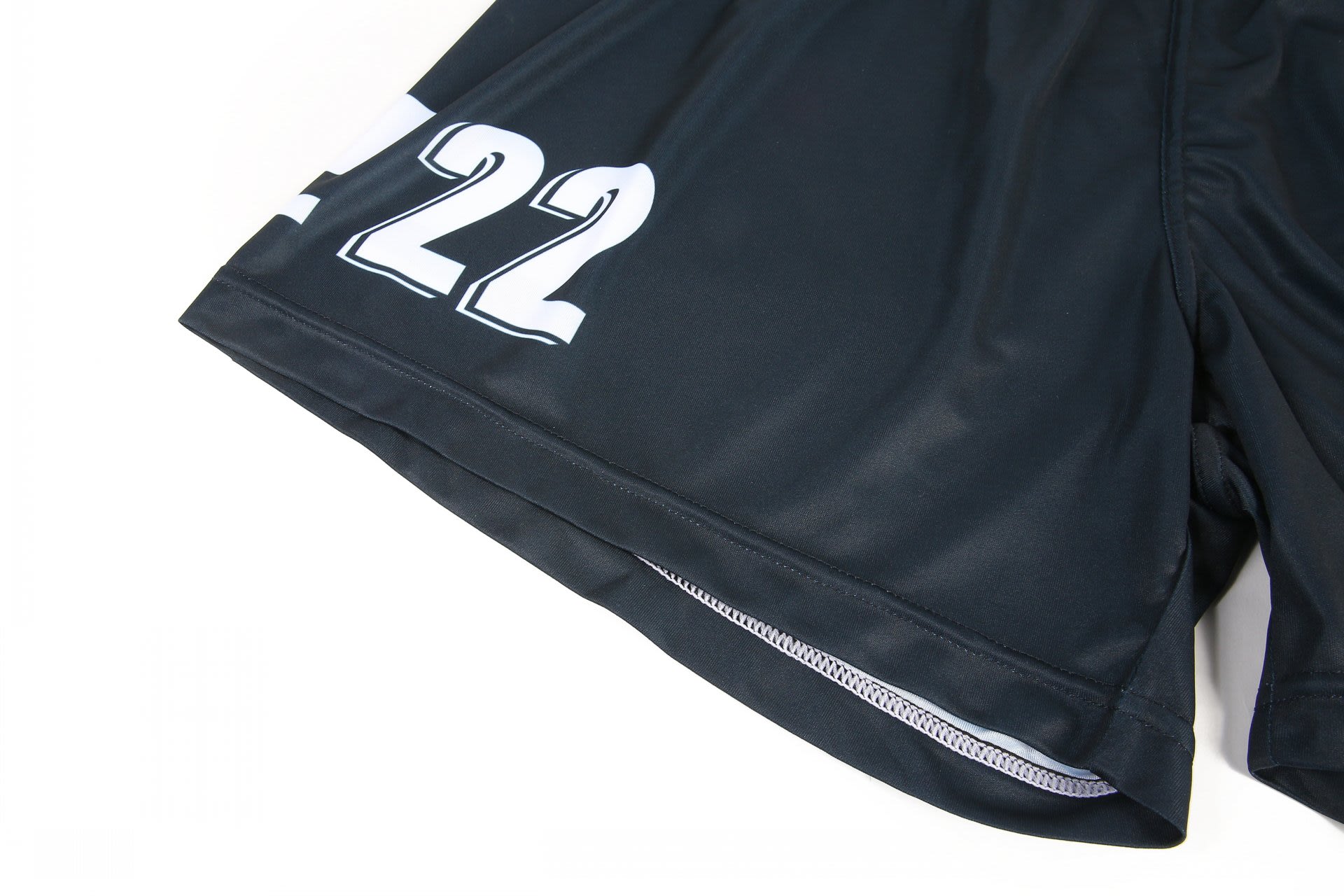 Black volleyball uniform shorts featuring a number design and a logo. The fabric appears lightweight and durable.