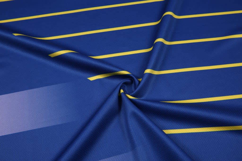 A blue and yellow striped fabric featuring a smooth mesh texture and a subtle sheen. It has a logo in one corner.