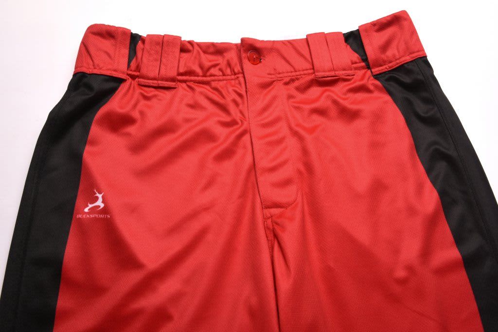 Red and black sports pants with a logo, featuring a button and two belt loops at the waist.