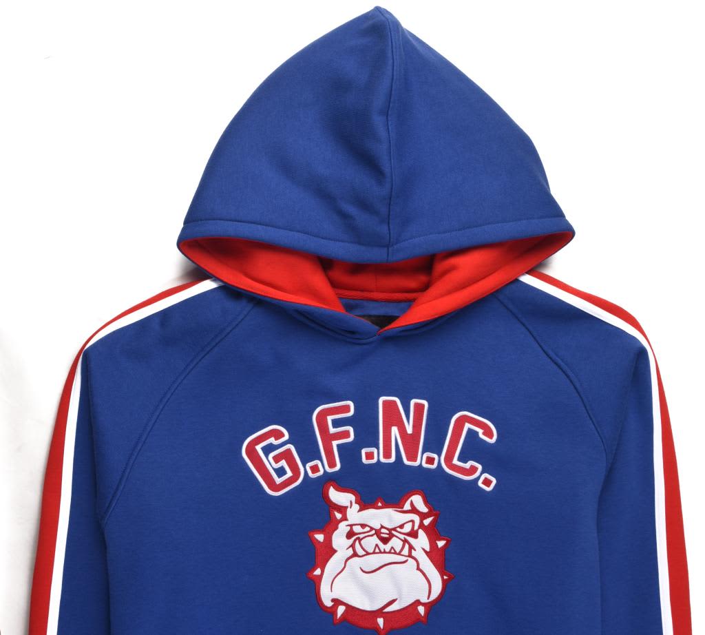 A blue and red hooded fleece sweatshirt with a logo and text on the front. The hood is prominent and the design features stripes.