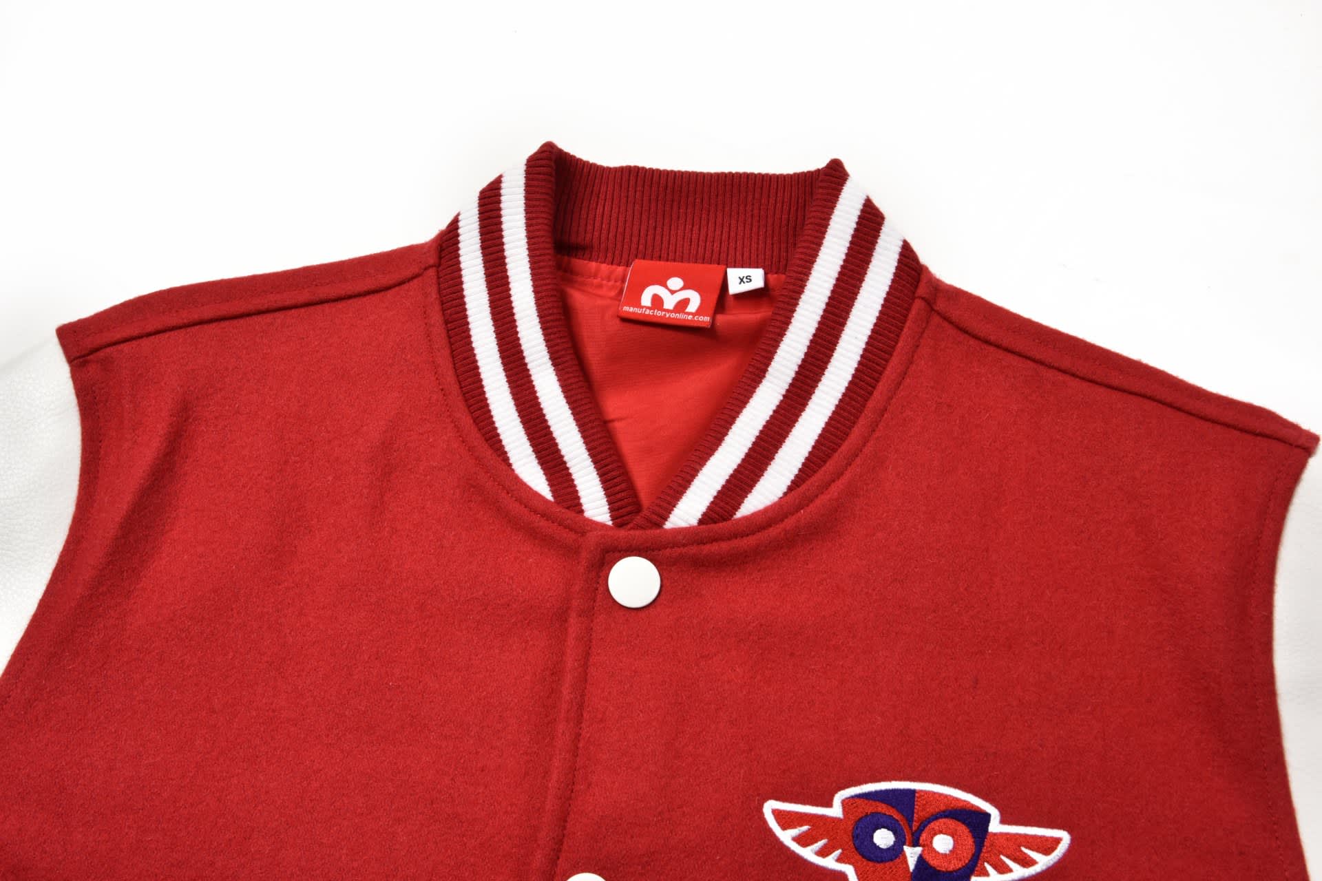 A red custom-made letterman jacket with white sleeves and a decorative logo on the front.