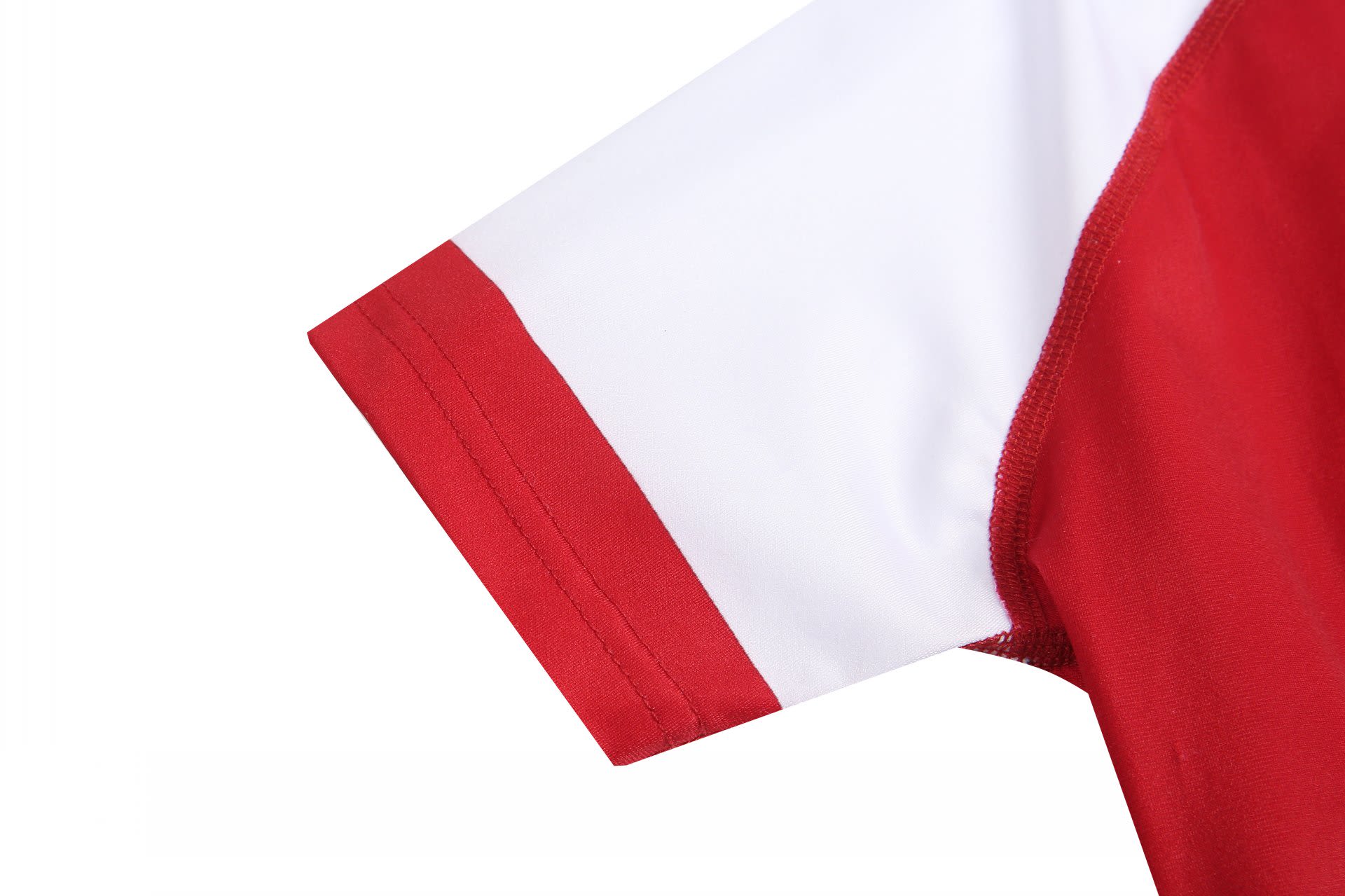 A red and white sports uniform featuring a short sleeve design, with a logo on the fabric.