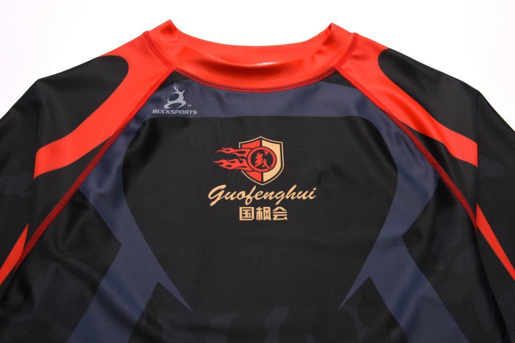 A black and red compression tee featuring a logo on the chest area.