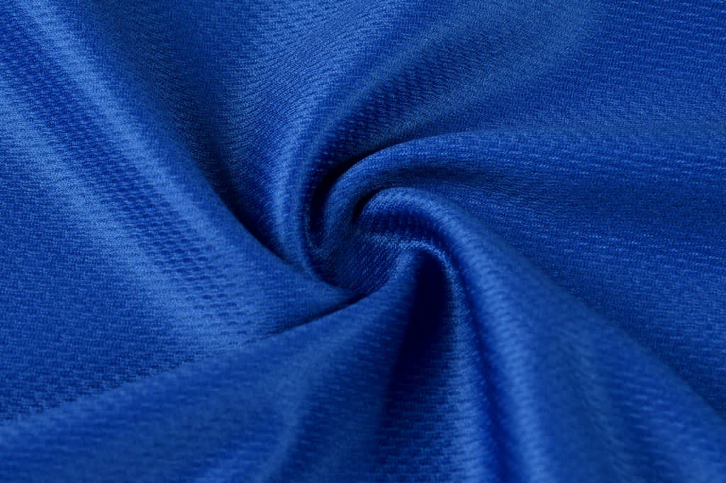 A close-up of textured, vibrant blue fabric, showcasing its smooth and soft material.