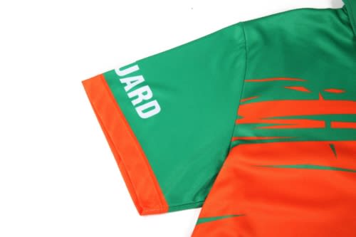 A quarter-zip uniform in vibrant green and orange, featuring a logo on the sleeve.