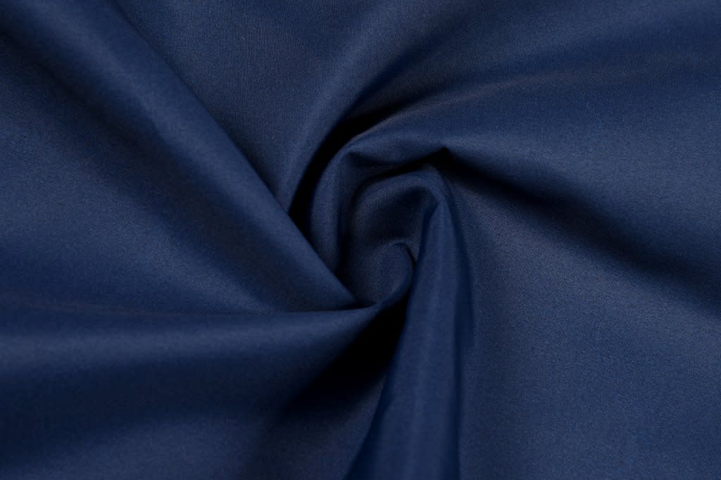 A close-up of navy blue cotton fabric with a smooth texture, showcasing its soft lining.
