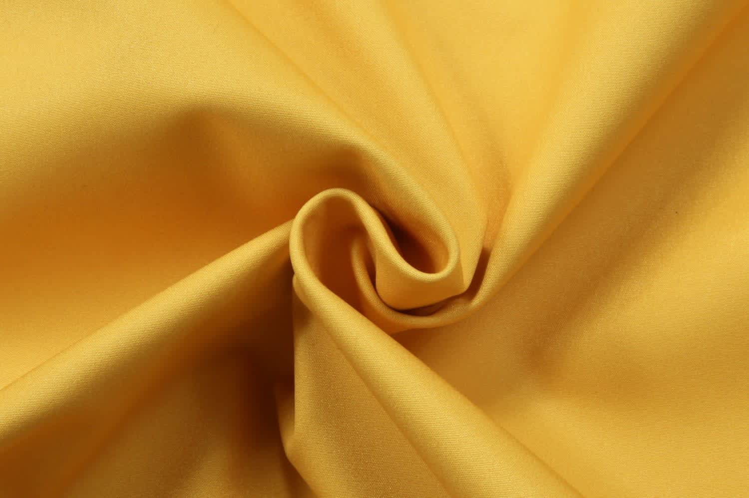 A soft, wrinkle-free fabric in a vibrant yellow hue, showcasing a smooth texture and a twist fold.