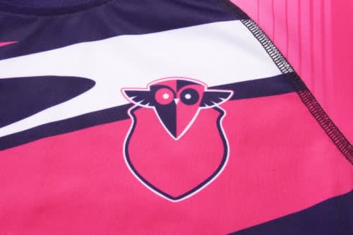 A close-up of a pink and navy sports uniform featuring a logo, designed for anti-chlorine swimming.