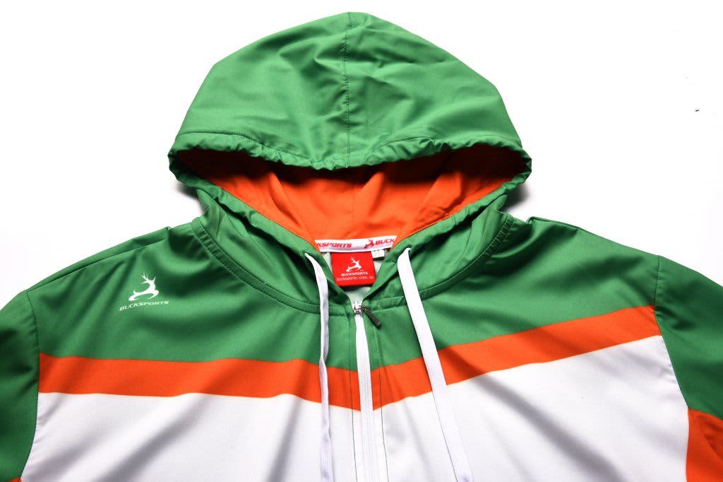 A junior hoodie in green, white, and orange, featuring a hood and a logo. Water-repellent material.