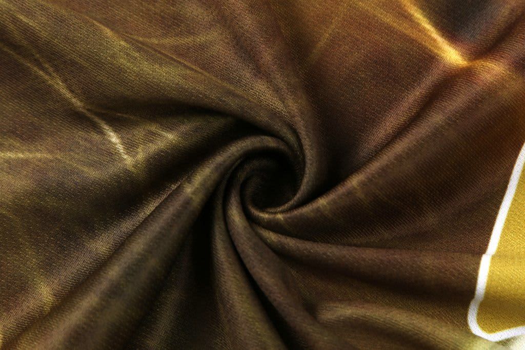 A close-up of patterned fabric featuring a leopard-like design in shades of brown and gold.