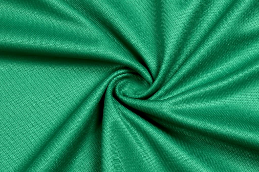 A custom-made t-shirt fabric in vibrant green, showcasing a textured, swirling pattern.