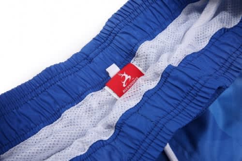A pair of blue shorts with a mesh lining and a logo label sewn into the waistband.
