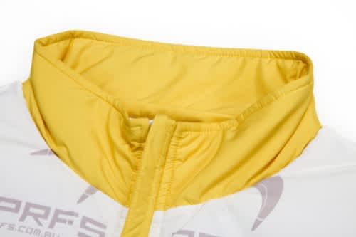 A close-up of a coat featuring a yellow collar and hood, part of a removable sleeves design.