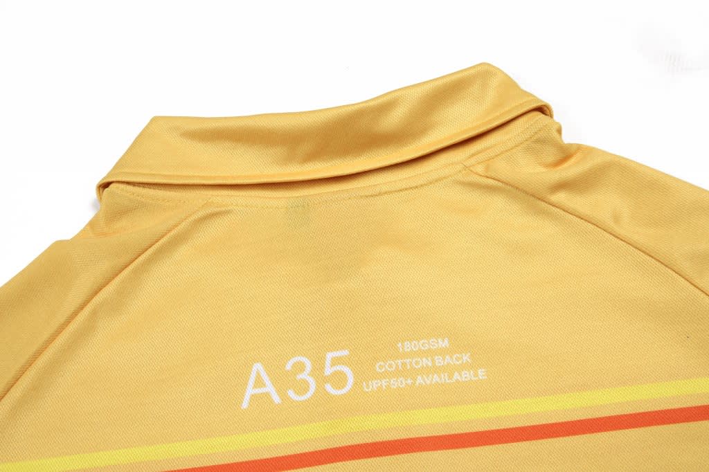 A yellow polo shirt with a collar and a logo, featuring orange and red stripes across the back.