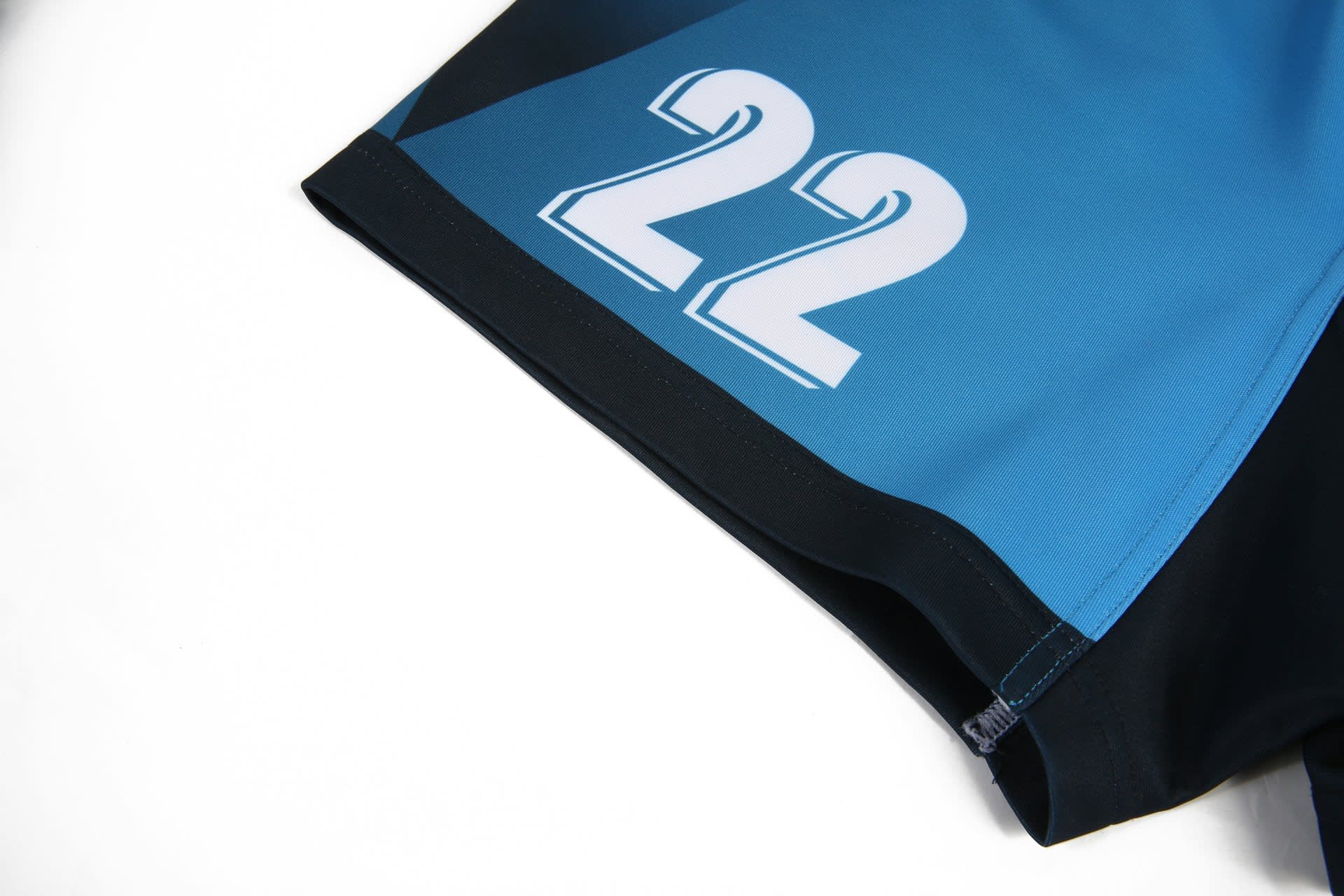 A pair of rugby uniform shorts in blue and black, featuring a large white '22' and a logo.