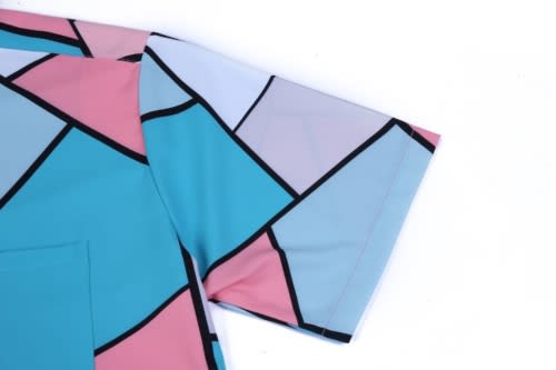 A vibrant, multicoloured shirt featuring a geometric pattern in pink, blue and purple tones, with a pocket on the chest.