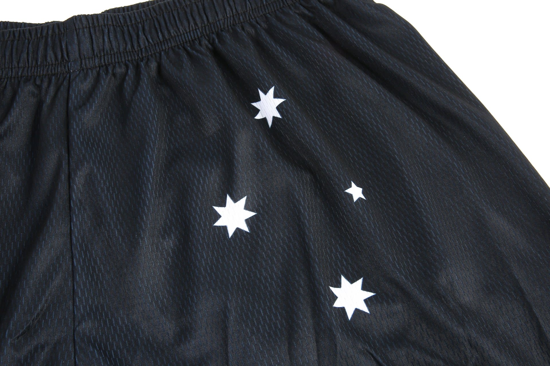 Black shorts featuring white star designs, made from lightweight material and with an elastic waistband.