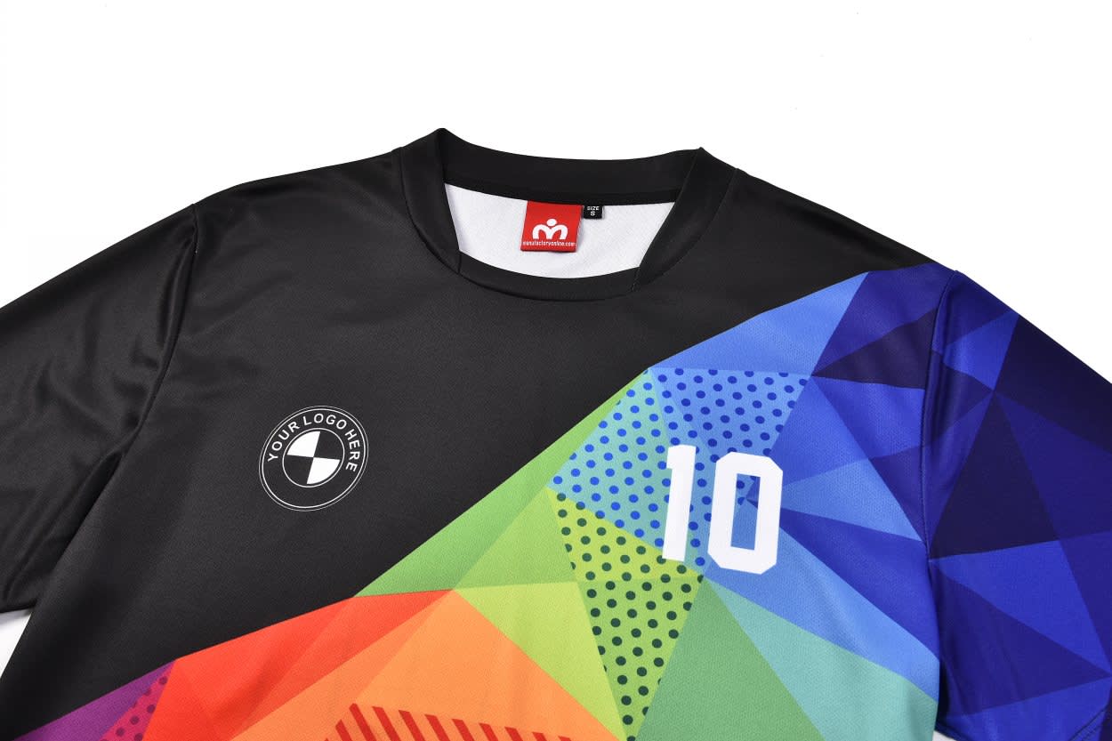 A black football top jersey featuring a multicoloured geometric design and a logo on the front.